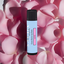 Load image into Gallery viewer, Sauda Love lip balm on a bed of pink rose petals