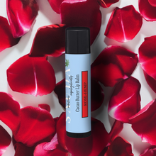 Load image into Gallery viewer, Lip balm tube on a bed of red rose petals

